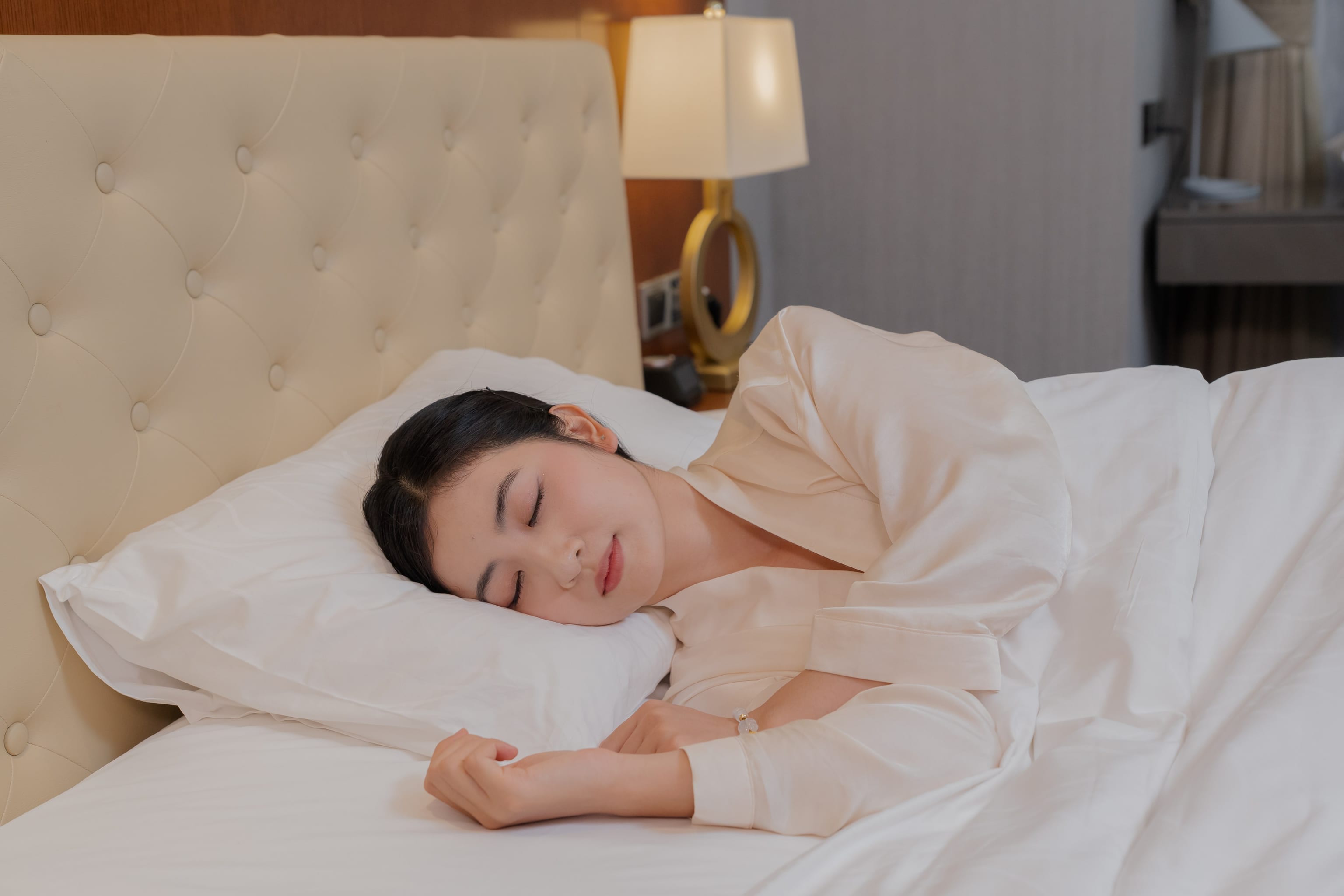 A mother resting under a thick blanket in a warm, well-aired room